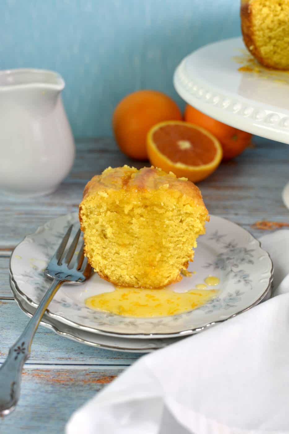 slice of orange cake on a plate with some orange glaze on it.