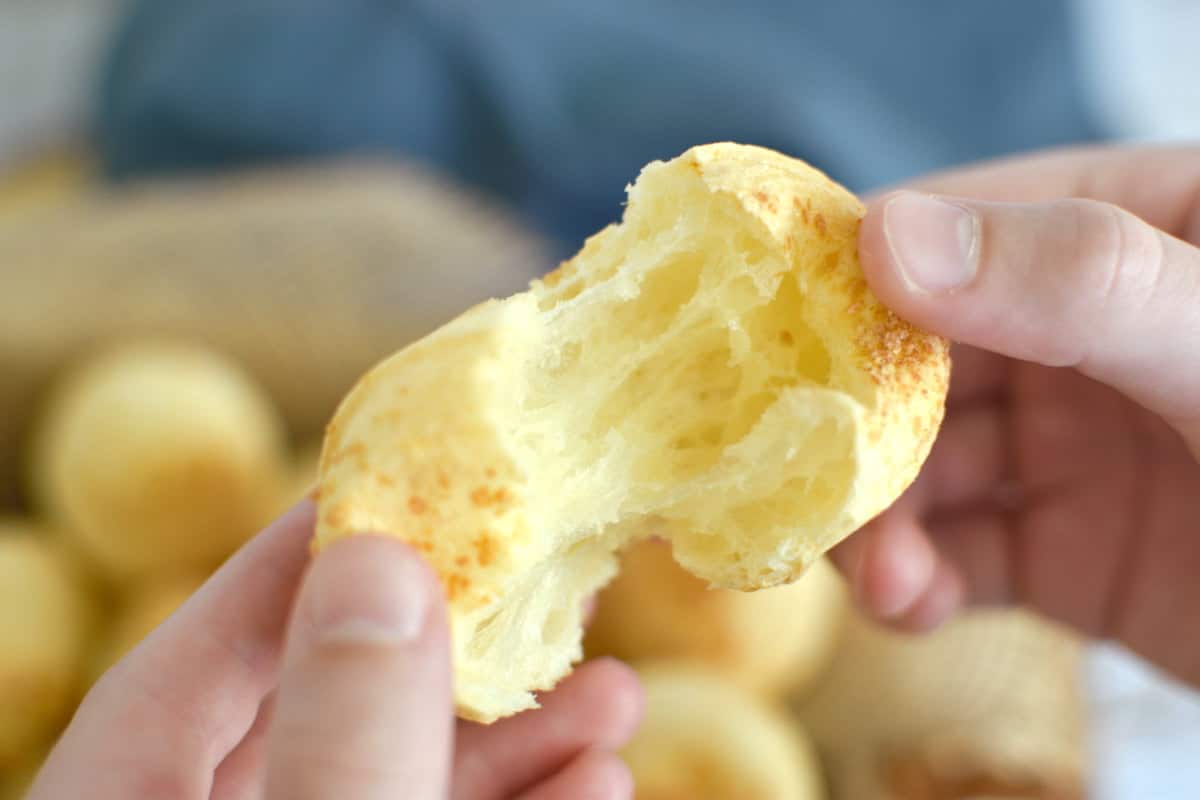 Brazilian cheese bread being opened, showing the inside