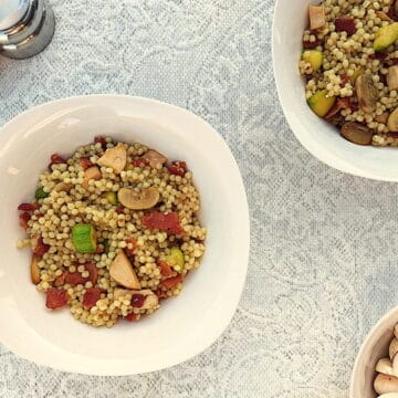 Israeli Couscous with bacon, zucchini and mushrooms, in a bowl.