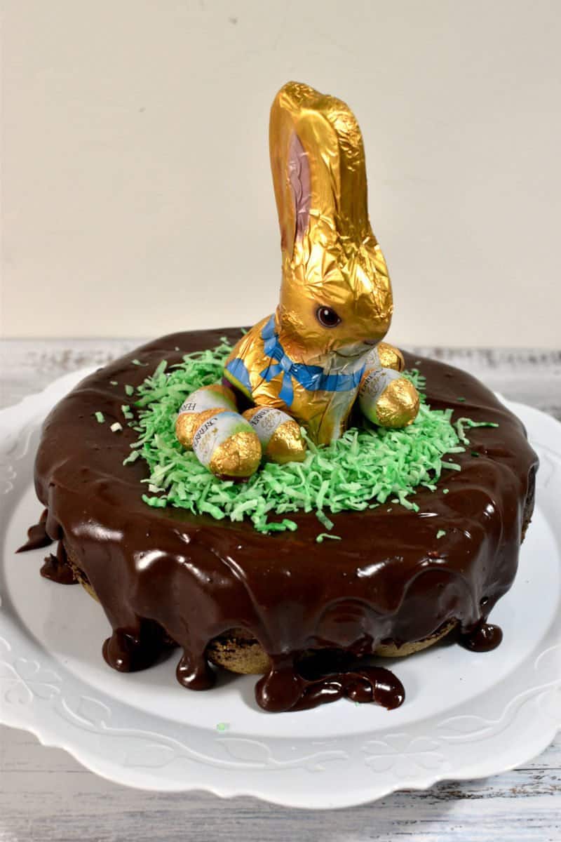 Easter chocolate cake topped with chocolate frosting brigadeiro, chocolate bunny and Easter eggs.