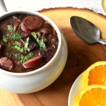 Feijão preto com carne de porco servido com laranja e farofa