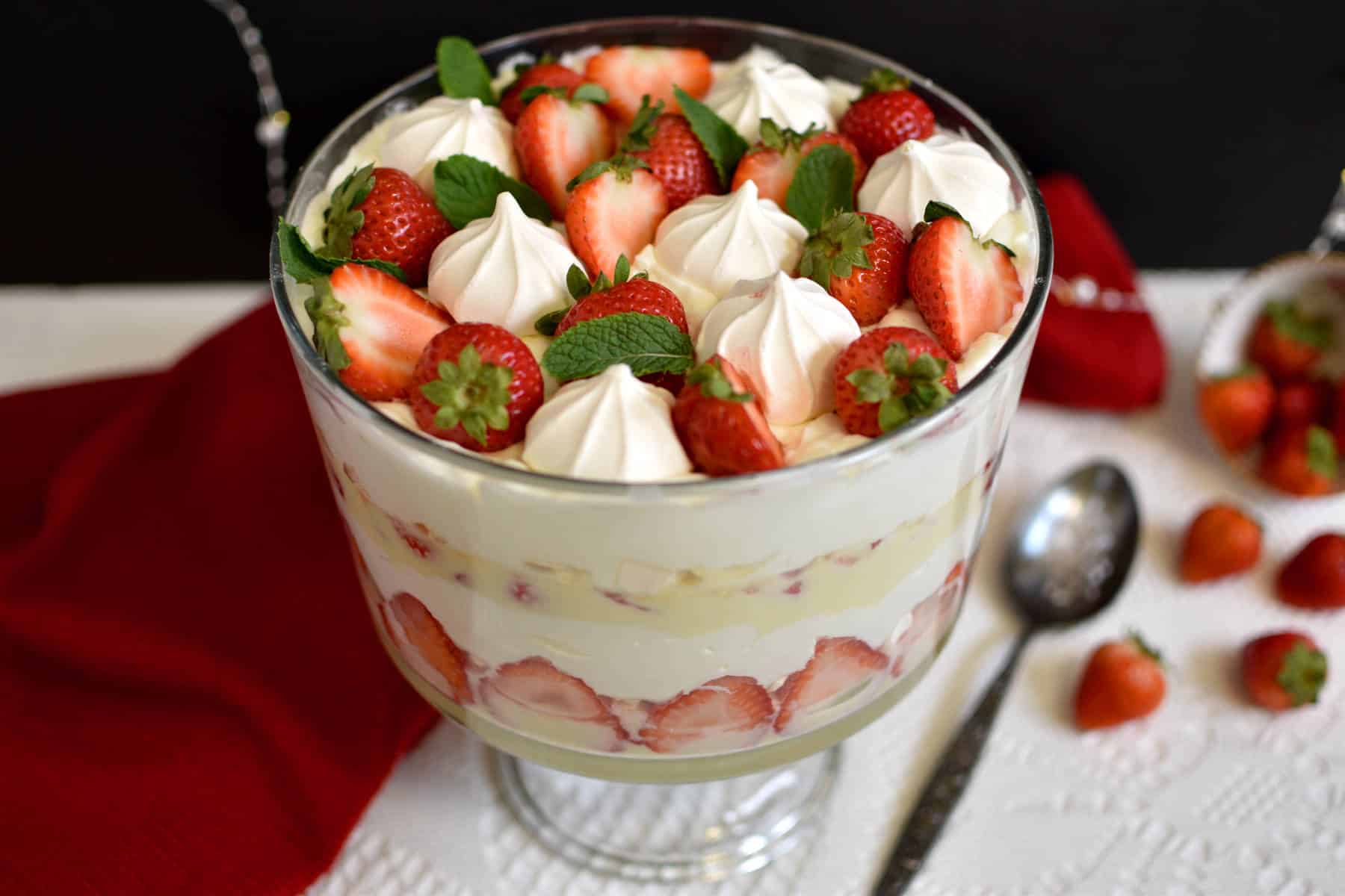 strawberry trifle with custard, whipped cream and merengue cookies