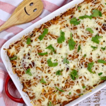 Frango com batata-doce na travessa, coberto com queijo e salsinha salpicada