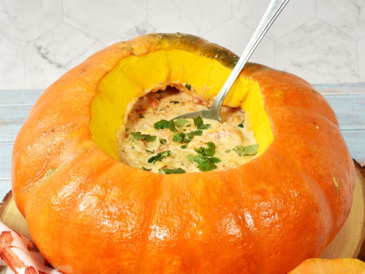shrimp chowder in a cinderella pumpkin with a spoon inside