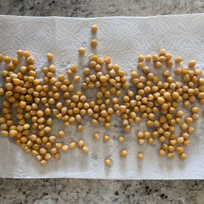 cooked chickpeas drying on a paper towel