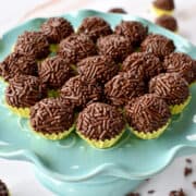 brigadeiros covered with chocolate sprinkles on a stand.