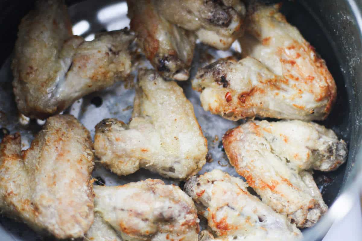 chicken wings air fried in air fryer tray.