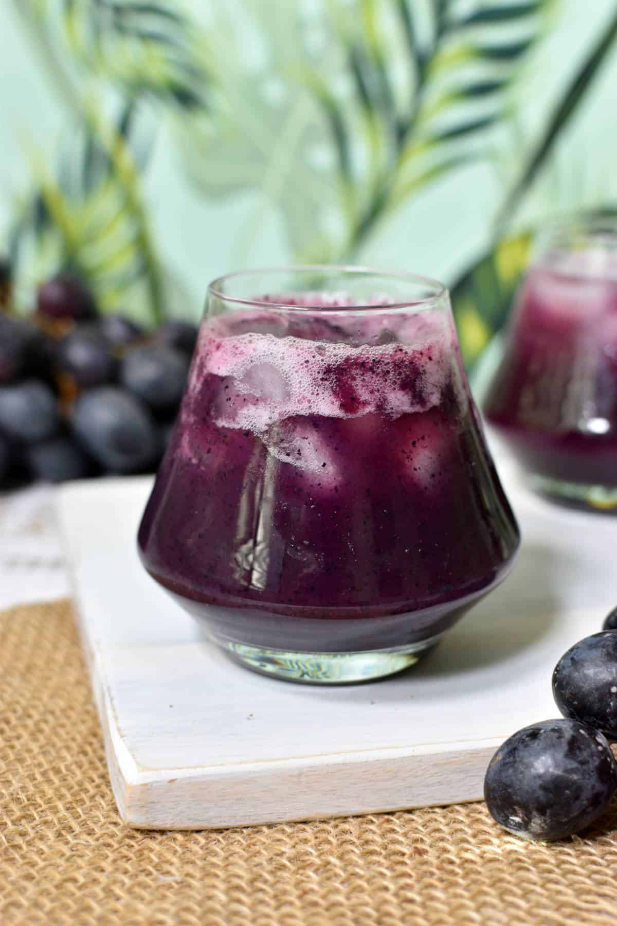 homemade grape juice in a cup with ice cubes.