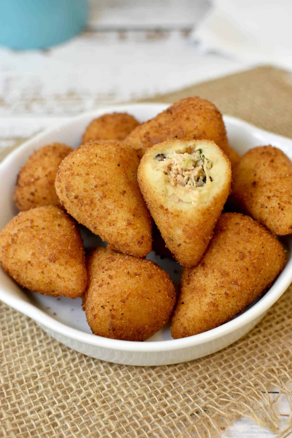Pile of Brazilian chicken croquettes with one opened on top