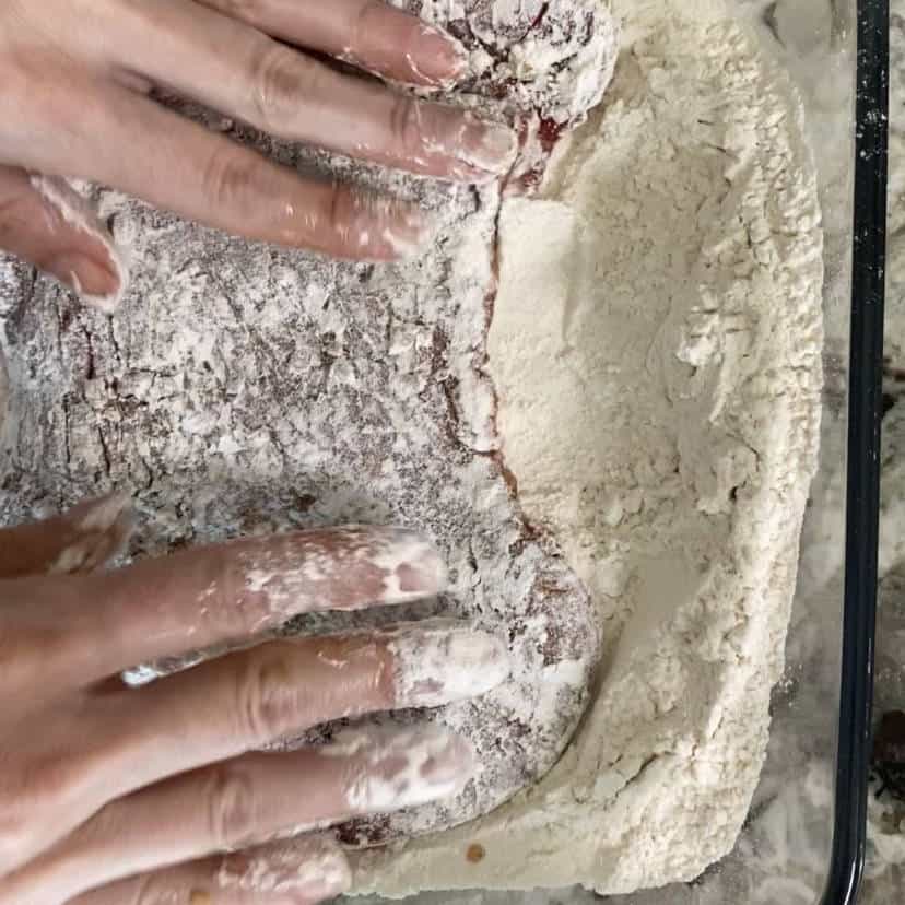 pressing a steak on the all-purpose flour.
